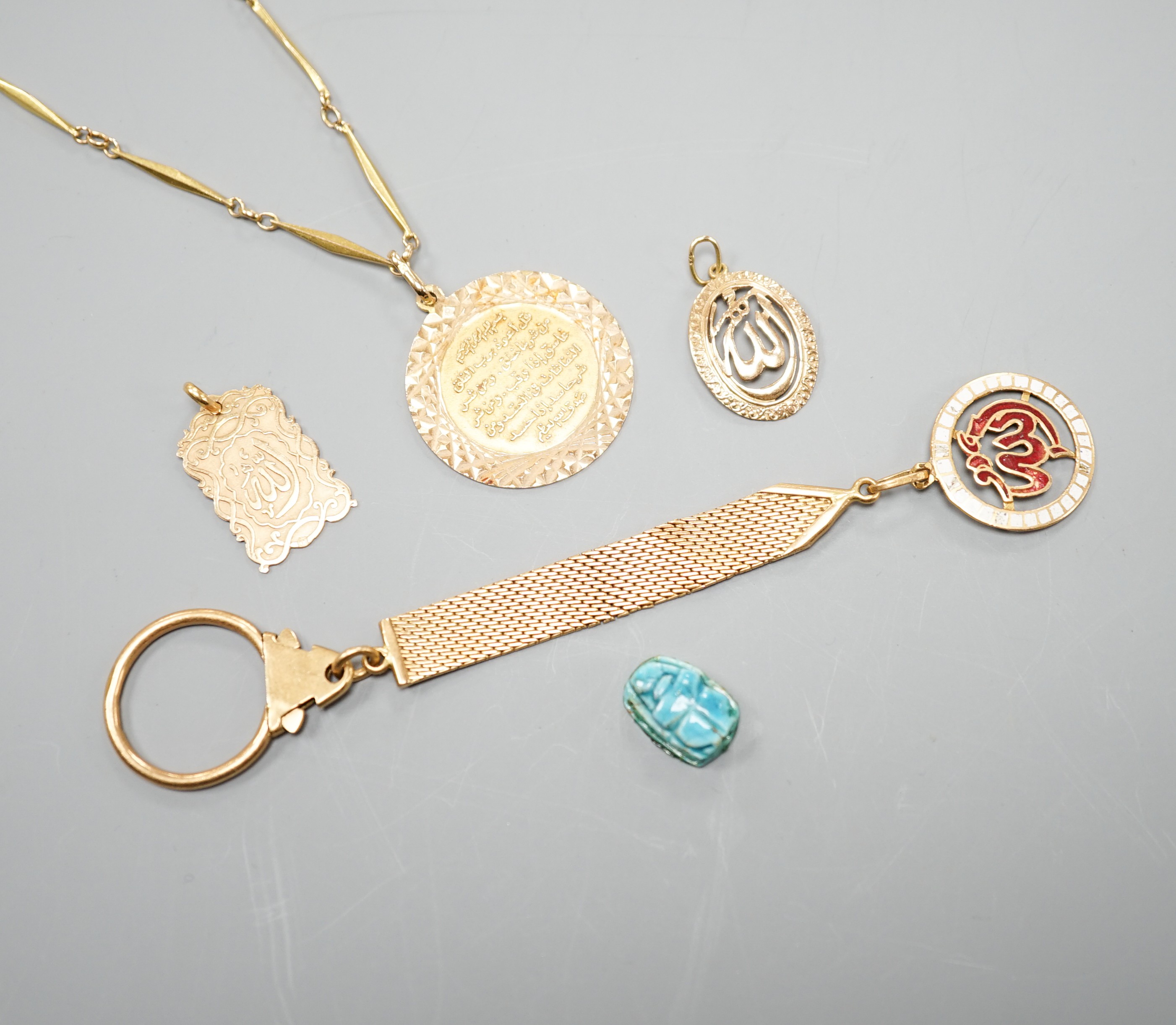 A Middle Eastern yellow metal and enamel pendant on a similar clip and three other Middle eastern pendants, one with chain, gross weight 34.5 grams and an Egyptian scarab.